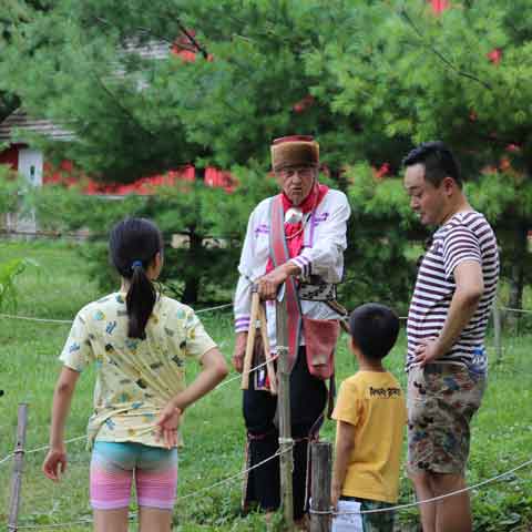 man dressed as a native American talking to visitors