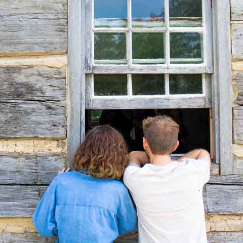 two visitors looking into a window
